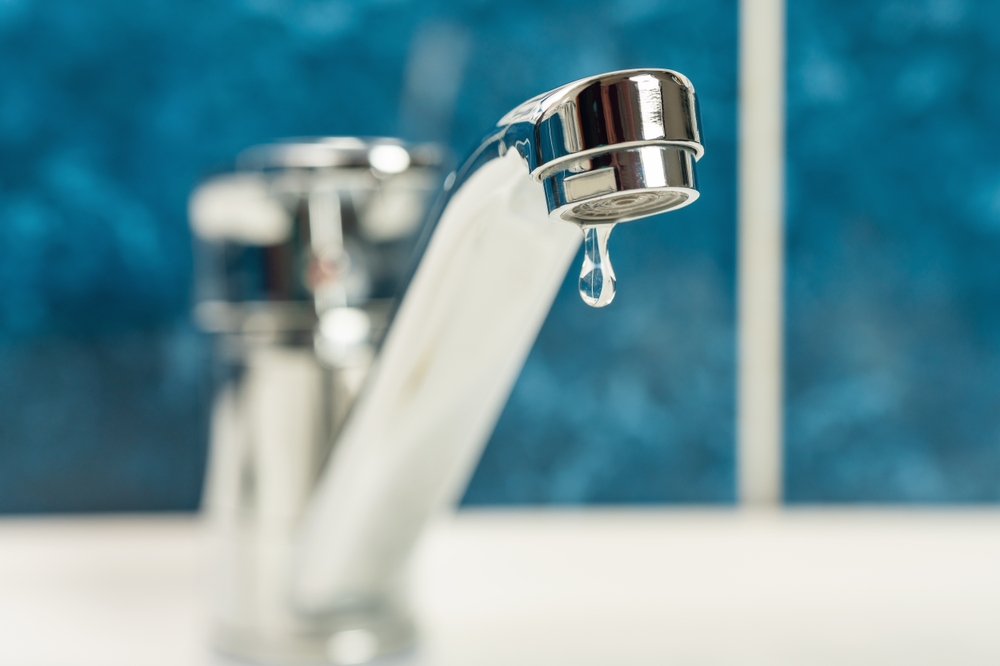 A drop of water drips from a leaky faucet.